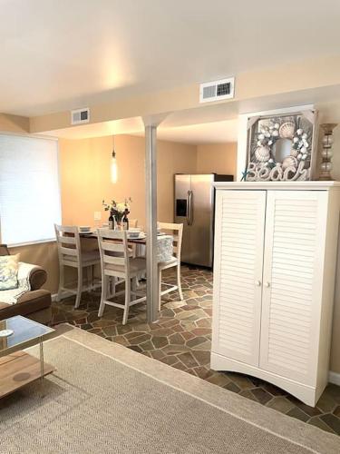 a kitchen and dining room with a table and a refrigerator at Beach gem! Hot Tub/EV/2bd/3.7mi beach/.5mi outlets in Rehoboth Beach