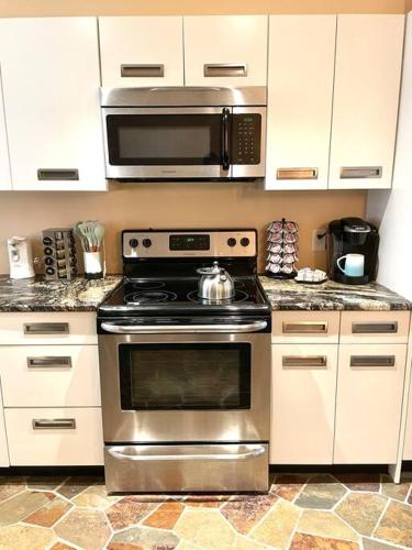 a kitchen with a stainless steel stove and a microwave at Beach gem! Hot Tub/EV/2bd/3.7mi beach/.5mi outlets in Rehoboth Beach