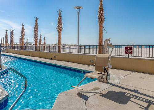 - une piscine dans un complexe avec une chaise dans l'établissement Phoenix All Suites Hotel, à Gulf Shores