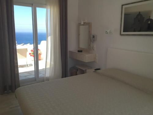 a bedroom with a bed and a view of the ocean at Hotel Spanelis in Mýkonos City