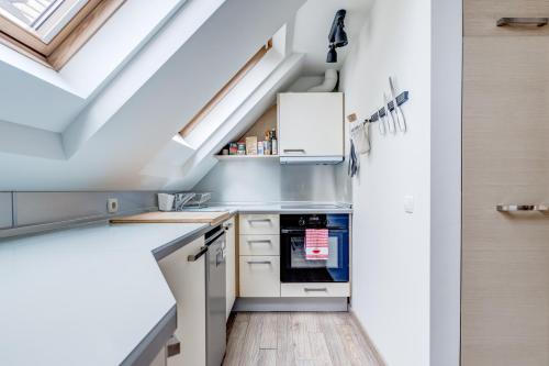 a kitchen with white cabinets and a skylight at Park Loft next to Eagle's Bridge in Sofia