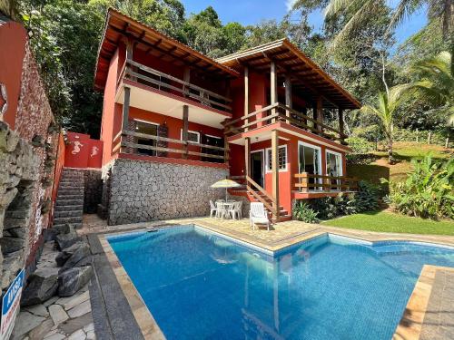 uma casa com piscina em frente a uma casa em Vista privilegiada para o mar 400 mts da praia em São Sebastião