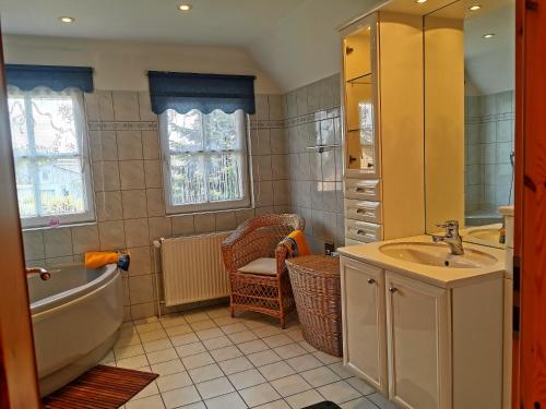 a bathroom with a tub and a sink and a bath tub at Ferienhaus Gartower See in Gartow