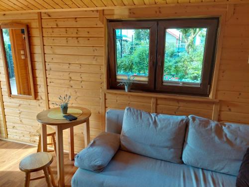 a living room with a blue couch and a table at Domek in Świnoujście