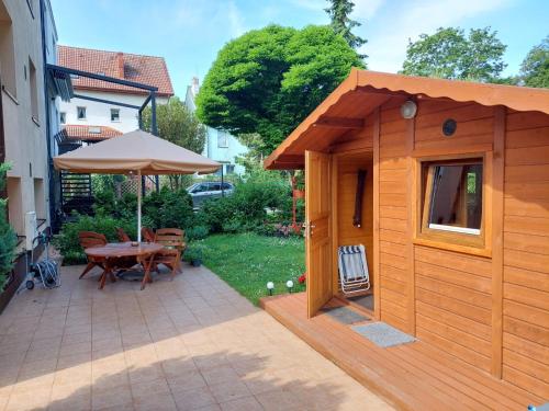 um pequeno barracão de madeira com uma mesa e um guarda-chuva em Domek em Świnoujście