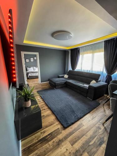 - un salon avec un canapé noir et une table dans l'établissement Relax House, à Craiova