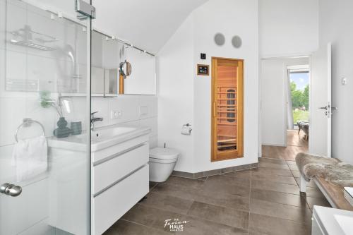 a white bathroom with a toilet and a sink at Große Freiheit in Olpenitz