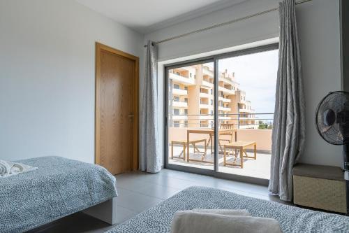 um quarto com uma cama e vista para uma varanda em Amazing Sea View Apartment Praia da Rocha em Portimão