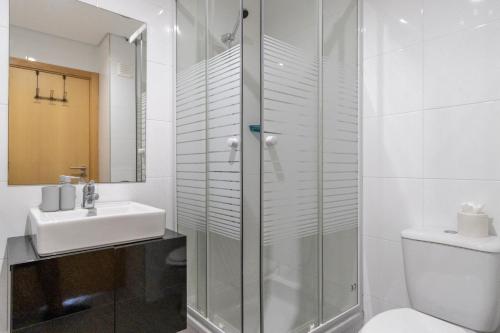 uma casa de banho com um chuveiro, um WC e um lavatório. em Amazing Sea View Apartment Praia da Rocha em Portimão