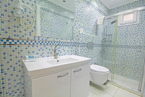 La salle de bains est pourvue d'un lavabo, d'une douche et de toilettes. dans l'établissement Nokta Kaya Suit Apart, Fethiye, Ölüdeniz, à Fethiye