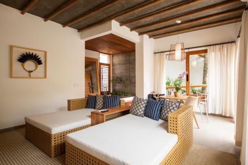 uma sala de estar com duas camas e uma mesa em Santa Aldeia Hotel em Arraial d'Ajuda