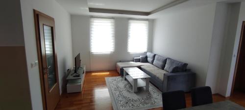 uma sala de estar com um sofá e uma mesa em Apartman NM em Foca