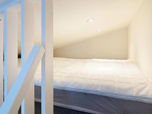 Un pequeño dormitorio con una cama y una escalera en Holiday home Sölvesborg XII, en Sölvesborg