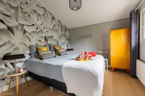 a bedroom with a bed with stuffed animals on it at NOFLIK, een gezellig chalet met een fraaie en rustige ligging in Stegeren