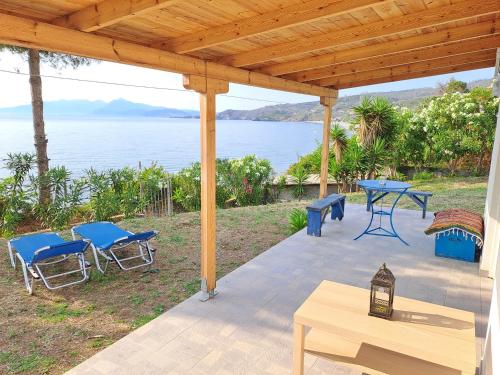 un patio con mesa y sillas y vistas al agua en Beach Studio Kotrona, en Achladi