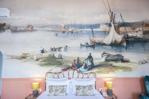 a mural on the wall of a room with a bed at Dar Alice in Soûr