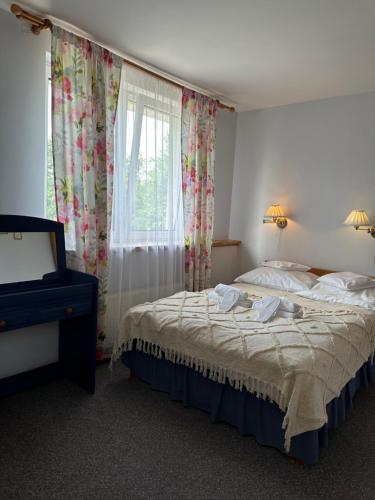 a bedroom with a bed and a window with curtains at Anielski Zakątek Polańczyk in Polańczyk