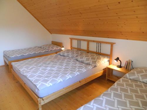 2 letti in una camera da letto con soffitto in legno di Chalupa u Lipna a Nová Pec