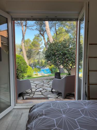 a bedroom with a large sliding glass door to a patio at Hôtel La Pinède in Saint-Marcellin-lès-Vaison