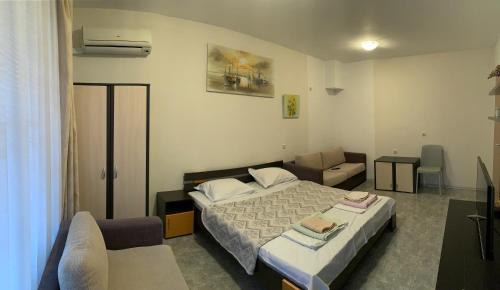 een hotelkamer met een bed en een bank bij Stamopolu apartment in Primorsko