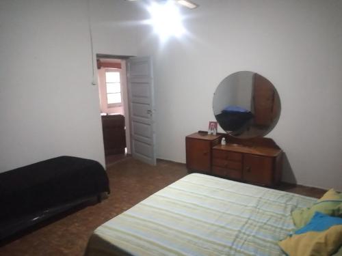 1 dormitorio con cama y tocador con espejo en Casita de mis viejos en Mendoza