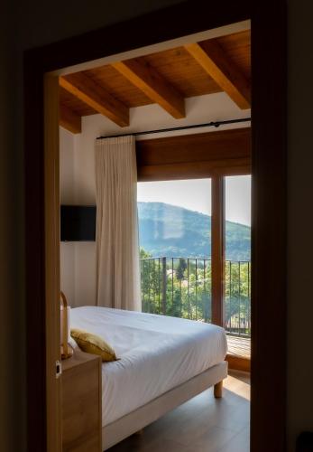a bedroom with a bed and a large window at Les Casetes de Molló in Molló