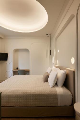 a bedroom with a bed with white pillows at DWELL - Elegant City Stay in Athens