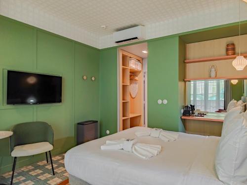 a bedroom with a white bed and a green wall at Aparthotel AMMI Nice Lafayette in Nice