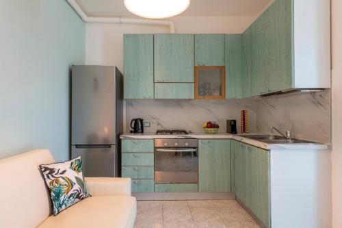 a kitchen with green cabinets and a refrigerator at La Casa del Pescatore in Cernobbio