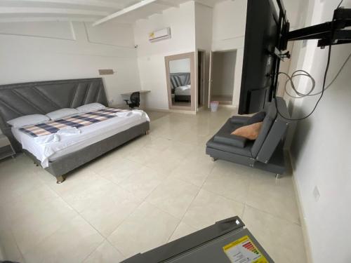 um quarto com uma cama e uma cadeira num quarto em Hotel Monaco em Tuluá