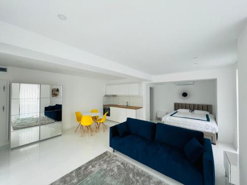 a bedroom with a blue couch in front of a bed at Oxygen Residence in Neptun