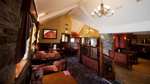 un ristorante con tavoli e sedie in una stanza di Corr's Corner Hotel a Newtownabbey