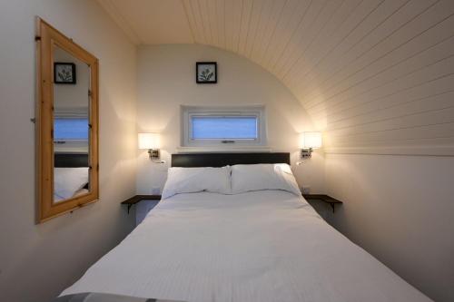 a white bed in a room with a window at Pinemarten Lodge in Roybridge