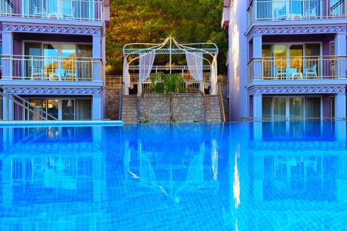 una grande piscina blu di fronte a un edificio di Nokta Katrancı Suit Apart, Fethiye, Ölüdeniz a Fethiye