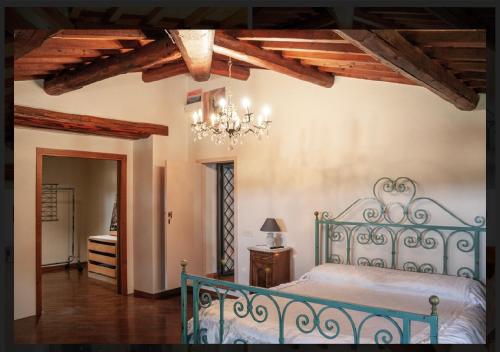 Casale di mamma Antonella في أريتسو: غرفة نوم بسرير ازرق وثريا