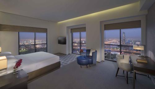 a hotel room with a large bed and a desk and a desk at Hyatt Regency Creek Heights Residences in Dubai