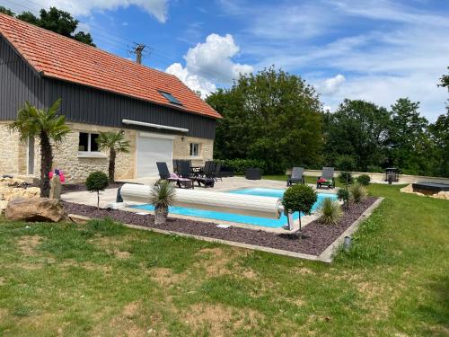 une piscine dans une cour à côté d'une maison dans l'établissement gîte Le Mont Marsis, à Gourdon