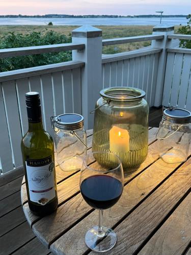 a glass of wine and a candle on a wooden table at Villa Wiegand - a room with a view in Holbæk