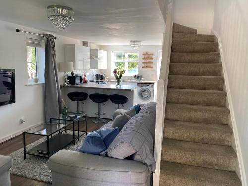 ein Wohnzimmer mit einer Treppe, einem Sofa und einer Küche in der Unterkunft Cheerful 2-bedroom home with free parking in Roughhill