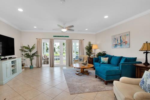 un salon avec un canapé bleu et une télévision dans l'établissement Three-Bedroom Townhouse, à Marathon