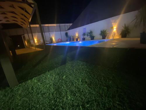 a house with a swimming pool at night at lacasa chalet private With a panoramic view of the DeadSea in Sowayma