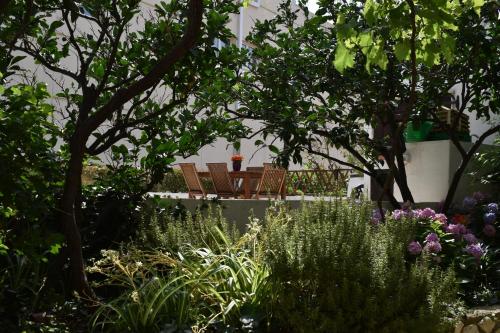 a garden with chairs and flowers and trees at Bel Posto Apartment in Dubrovnik