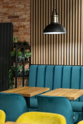a dining room with two tables and blue chairs at Stawa Villa & Apart in Świnoujście