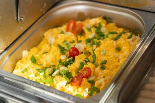 a container of food with tomatoes and green onions at Stawa Villa & Apart in Świnoujście