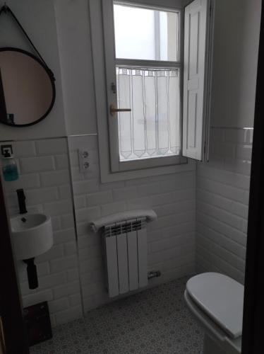 a bathroom with a toilet and a sink and a window at EL CAPRICHO DE BACO in Haro