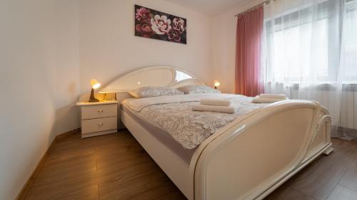 a bedroom with a large bed with two towels on it at Holiday Home TILEMIDA in Fužine