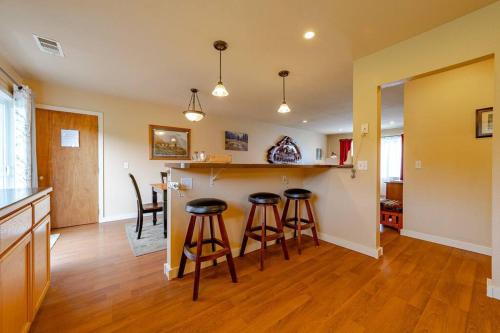 a kitchen with two bar stools and a counter at Elk Meadow Cabins 11A Roosevelt Elk Suite in Orick