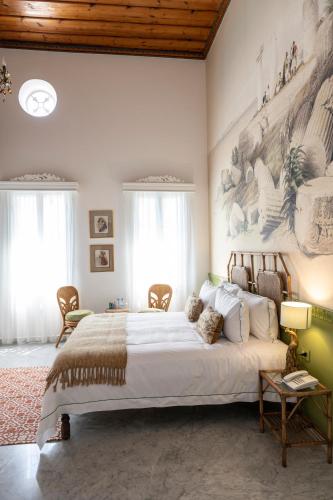 a bedroom with a large bed with a painting on the wall at Dar Alice in Soûr