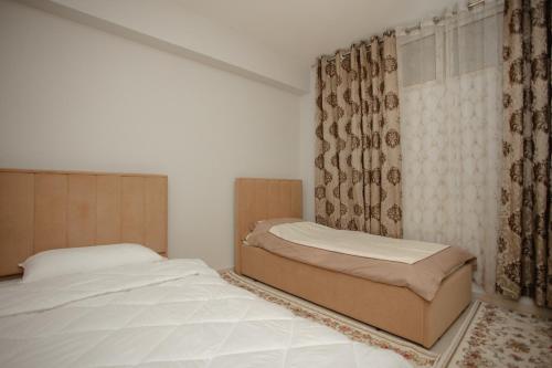 um quarto com 2 camas e uma janela em City Center Apartment Scutari em Shkodër