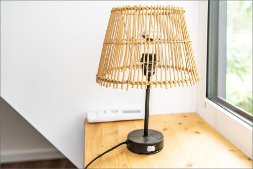 a lamp sitting on top of a wooden table at Rytas cozy apartment in the guest house with the terrace and the stunning view to the river side in Birštonas